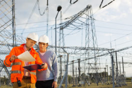 Male architects reviewing documents together at electric power plant